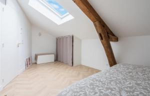 an attic bedroom with a bed and a window at Hébergement autonome Green in Esbly