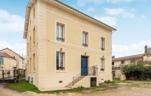 a large white building with a blue door at Hébergement autonome Green in Esbly