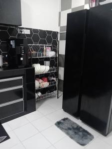 a kitchen with a black refrigerator in a room at Homestay suria in Gambang