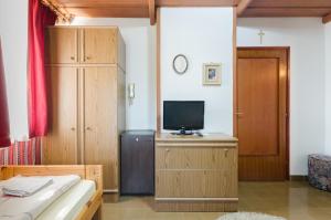 a bedroom with a bed and a tv on a cabinet at Família Panzió in Pannonhalma