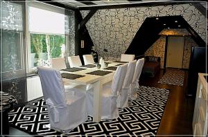 a dining room with a table and white chairs at FeWo Schwedenhaus in Eschede