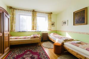 um quarto com três camas e uma janela em Família Panzió em Pannonhalma