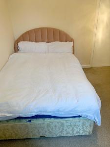 ジョンストンにあるNeat double room available in a 2 bedroom flatの部屋にある白いシーツと枕が置かれたベッド