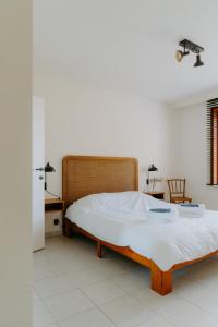 a bedroom with a bed and a table and a chair at Prachtig, rustig en ruim appartement vlakbij zee in Koksijde