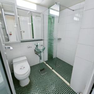 a bathroom with a toilet and a glass shower at Guri Home in Guri +5 photos