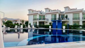 a large house with a swimming pool in front of it at Sea Magic Royal - Ruhiges Apartment mit Dachterrasse und Meerblick in Ayios Yeoryios