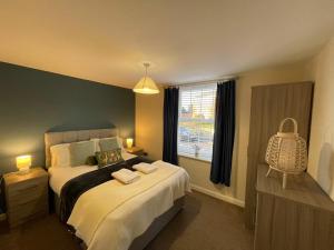 ein Schlafzimmer mit einem großen Bett und einem Fenster in der Unterkunft Barroon Castle Apartments - Next to East Midlands Airport with Free Parking in Castle Donington