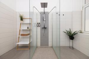 une salle de bain avec une douche avec une porte vitrée dans l'établissement 2BR central in Neukölln Maybachufer, à Berlin