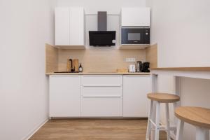 une cuisine blanche avec des armoires blanches et un micro-ondes dans l'établissement 2BR central in Neukölln Maybachufer, à Berlin 12 autres photos