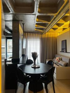 a living room with a table and a couch at Loft Industrial - Edifício Vista Mare apto novo in Torres +26 photos
