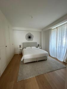 a white bedroom with a bed and a rug at Le nid de Montreux in Montreux +13 photos