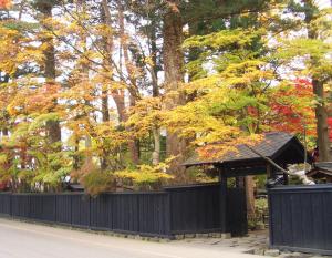 a black fence with a gazebo in front of trees at Hotel B4T Kakunodate in Senboku