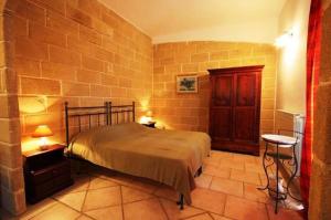 アルベロベッロにあるレジデンツァ デ レオナルディス のレンガの壁、ベッド付きのベッドルーム1室