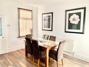 a dining room with a wooden table and chairs at Urba Luxury Stays 4Bed Sheffield University in Neepsend