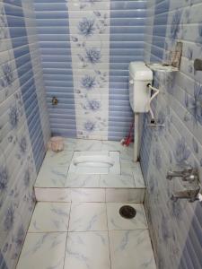 y baño con azulejos azules y blancos y lavabo. en Awadh Nikunj Homestay, en Ayodhya