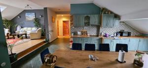 a kitchen with blue cabinets and a table and chairs at Apartament w Komornikach in Komorniki