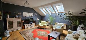 a living room with chairs and a tv and windows at Apartament w Komornikach in Komorniki