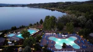 Draufsicht auf ein großes Schwimmbecken neben einem See in der Unterkunft De Santi in Candia Canavese