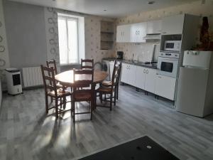 a kitchen with a table and chairs in a room at le chêne in Créancey