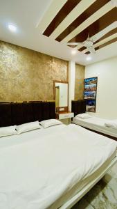 Un dormitorio con dos camas y un techo. en Hotel Malay INN, en Ujjain