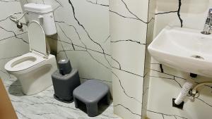 un baño con inodoro y lavabo en Hotel Malay INN, en Ujjain