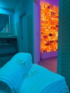 a bedroom with a bed with a lit up wall at Hotel Butterfly Wellness & Spa in Rimini
