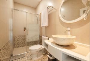 a bathroom with a sink and a toilet and a mirror at Flamingo Aquila in Uluwatu