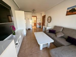 una sala de estar con un sofá y una mesa en Ático Al-Andalus, en Vera