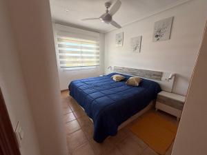 Un dormitorio con una cama azul y un ventilador de techo. en Ático Al-Andalus, en Vera 29 fotos más