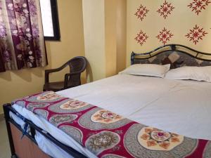 a bedroom with a bed with a blanket on it at Hotel Sai Satya in Shirdi