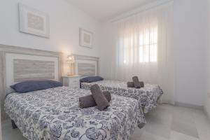 two beds in a bedroom with white walls at Winter Deal - Luxury Apartment with Terrace Mountain Views Near Beach in Fuengirola +23 photos
