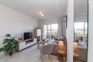a living room with a couch and a tv at Winter Deal - Luxury Apartment with Terrace Mountain Views Near Beach in Fuengirola