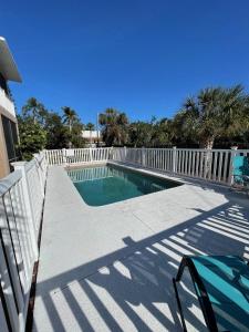 a swimming pool next to a white fence at Gorgeous condo with pool view in walking distance to Siesta Key Beaches in Sarasota