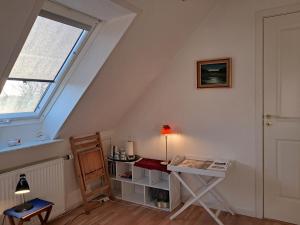 a attic room with a desk and a window at Hytten in Frøstrup