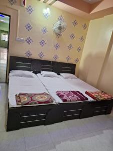 a large bed in a room with snowplets on the wall at Hotel Sai Satya in Shirdi +6 photos