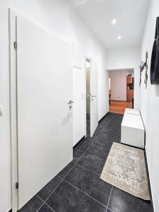 pasillo con puertas blancas y suelo de baldosa en Stockerau Sky Terrace, en Stockerau