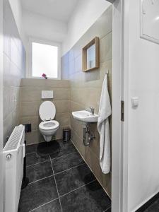un baño con inodoro y lavabo en Stockerau Sky Terrace, en Stockerau