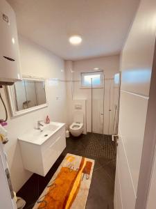 a bathroom with a white sink and a toilet at Apartman Vito in Kupres +31 photos
