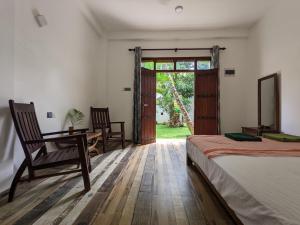 una camera da letto con un letto, una scrivania e una finestra di Caspian Mirissa a Mirissa