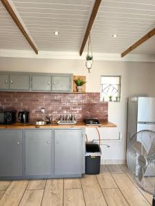 cocina con fregadero y pared de ladrillo en Just Stay, en Bloemfontein 1 foto más