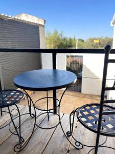 Una mesa azul y dos sillas en un balcón. en Just Stay, en Bloemfontein