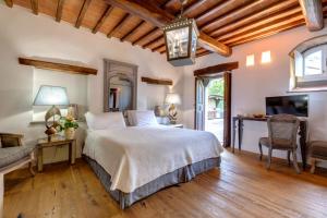a bedroom with a bed and a couch and a tv at Amore Rentals - Ville Il Paradiso in Panzano +60 photos