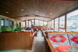 a dining room with tables and chairs and windows at Zeus Cave Suites in Göreme