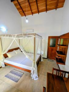 una camera da letto con un letto a baldacchino di Sawandara Garden Ayurveda Resort & Spa a Dikwella
