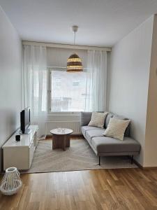 ein Wohnzimmer mit Sofa und Fernseher in der Unterkunft City apartment Kuopio Satamankulma, free parking, wifi & sauna in Kuopio