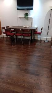 a dining room table with red chairs and a table at Luton Excellent 1 bed apartment with living room in Luton