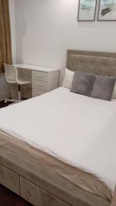 a bedroom with a large bed and a desk at Luton Excellent 1 bed apartment with living room in Luton