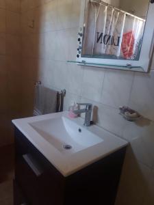 a bathroom with a white sink and a mirror at Departamento Cerca Parque Termal Rodo-Hue 2 in Dolores +4 photos