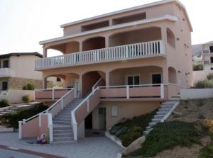 a large building with stairs in front of it at Apartments Bolont in Pag