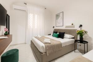 Un dormitorio con una cama grande con almohadas verdes. en White Flat Sanniti, en Roma
